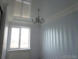 Белый лаковый натяжной потолок в спальне