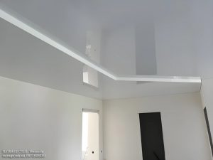 Белый глянцевый натяжной потолок в коридоре