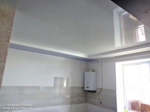 Белый глянцевый натяжной потолок на кухне.