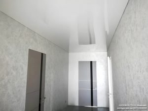 Белый глянцевый натяжной потолок в коридоре